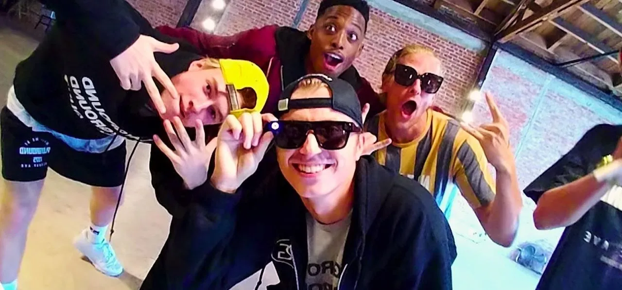 Group of young people posing playfully in sunglasses.