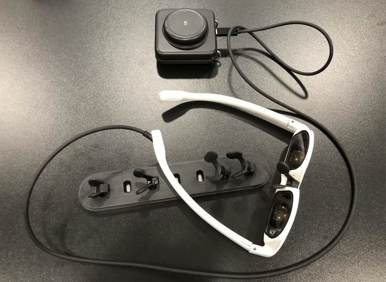 Sunglasses and a camera on a black surface.