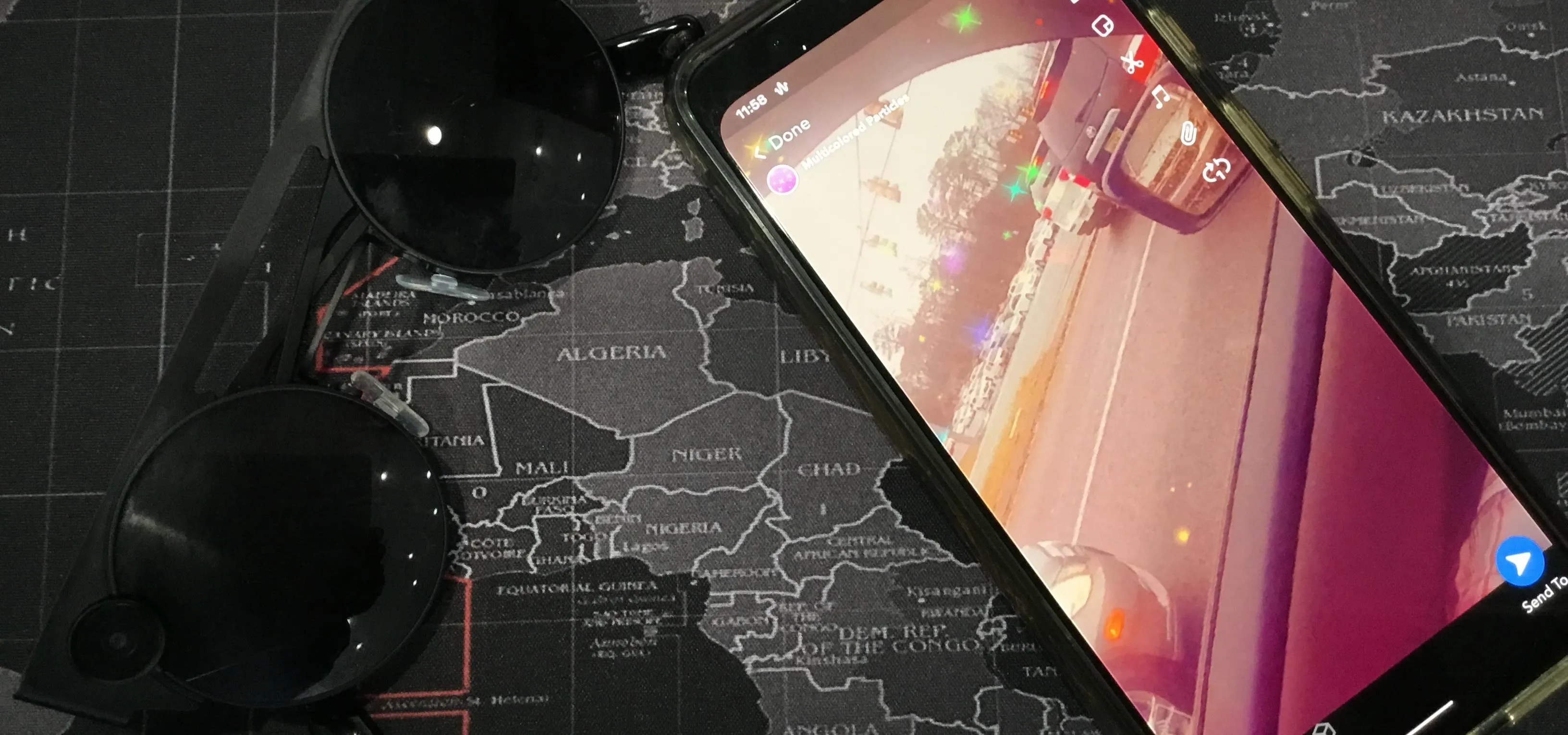 Sunglasses and a smartphone displaying a navigation app on a map background.